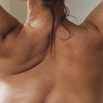Self loving attractive woman plus size in underwear from back near window at light room, body love