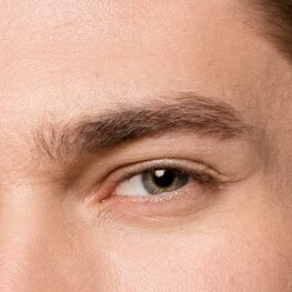 sexy man with bare torso pinching brows with tweezers isolated on grey