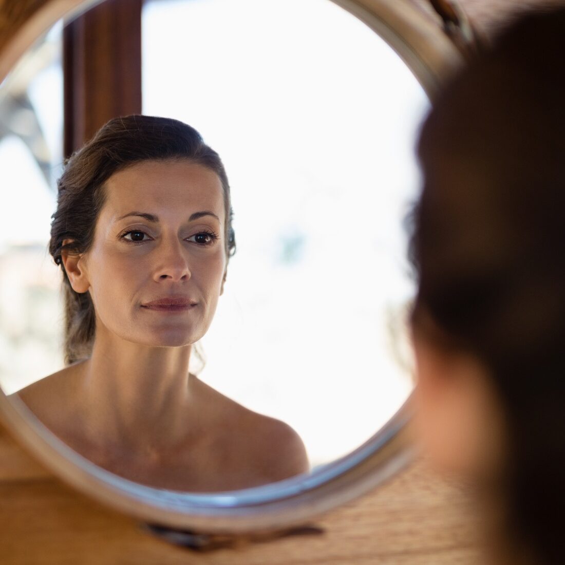 Woman looking at mirror in cottage